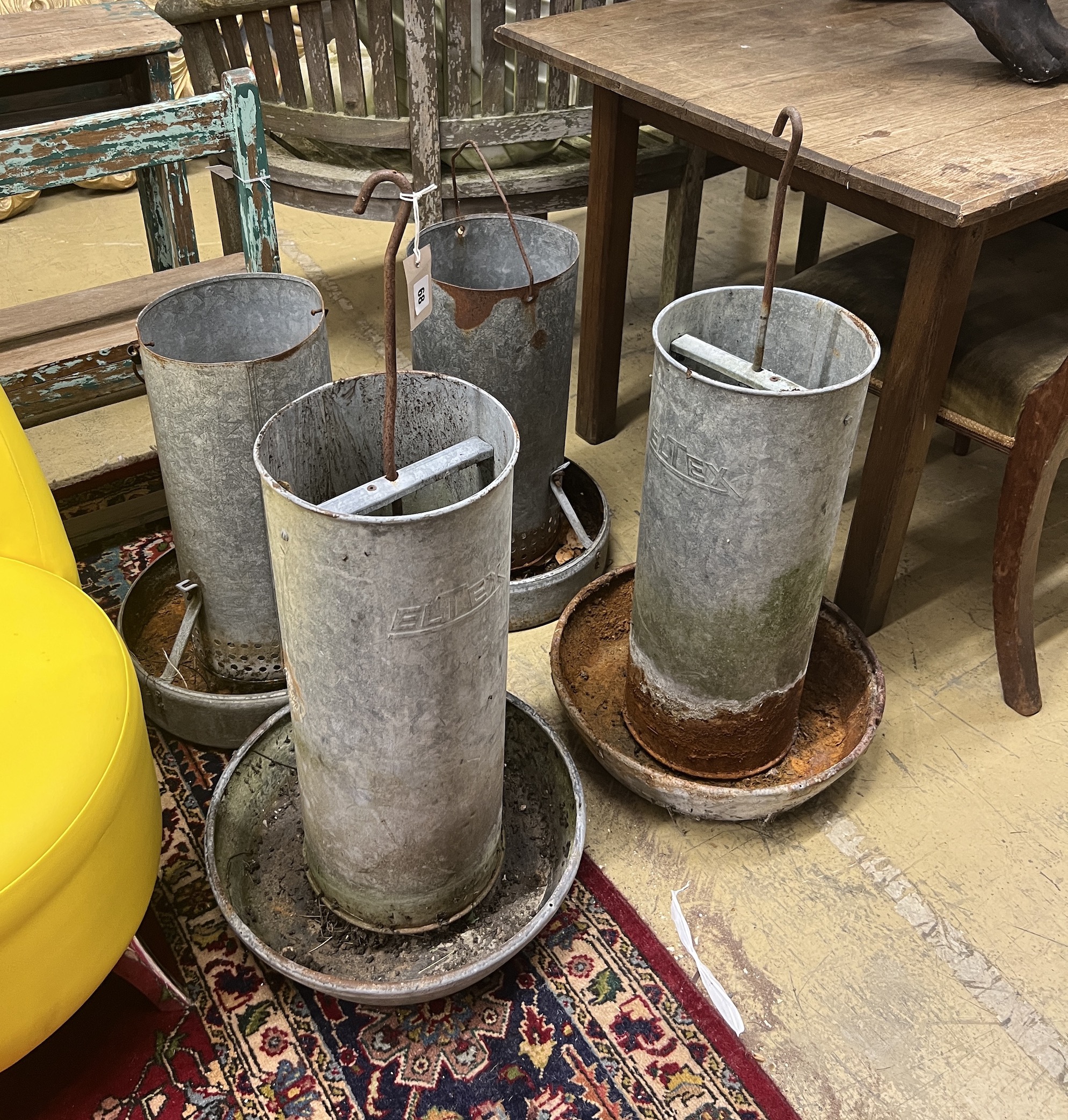 Four vintage galvanised poultry feeders, largest height 62cm